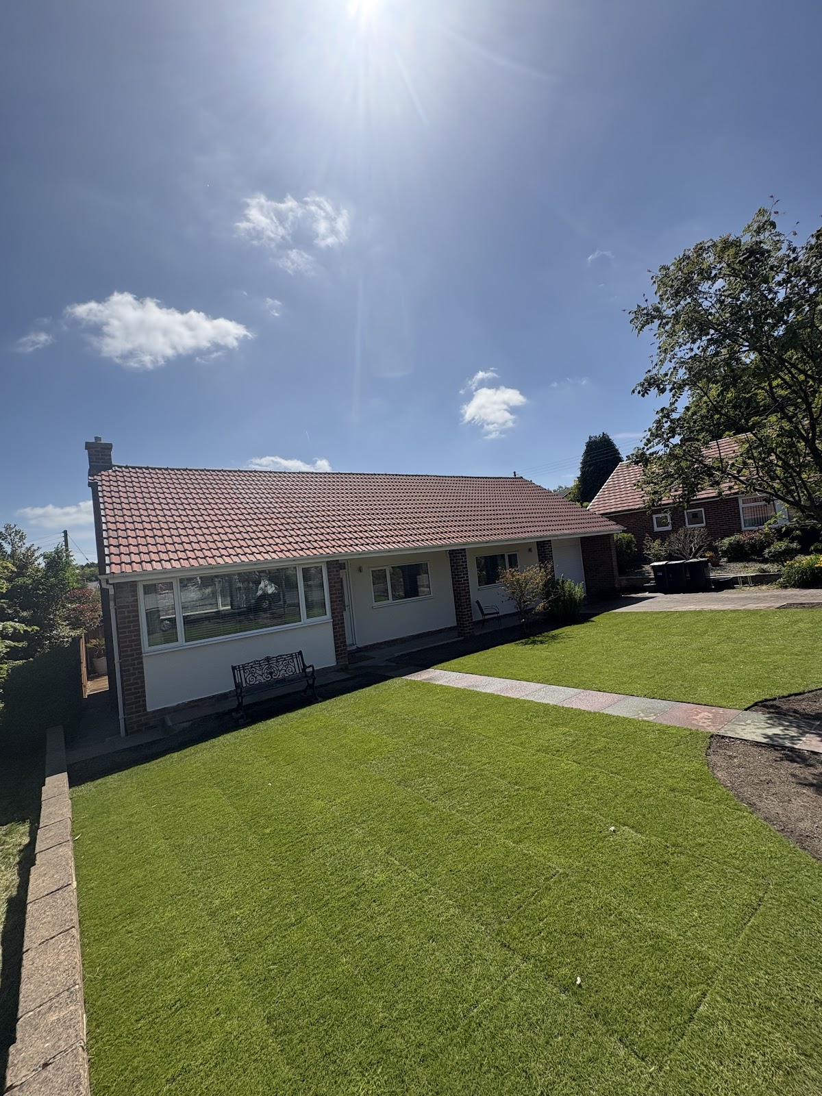 Fresh turf lawn laid at a bungalow on a sunny day