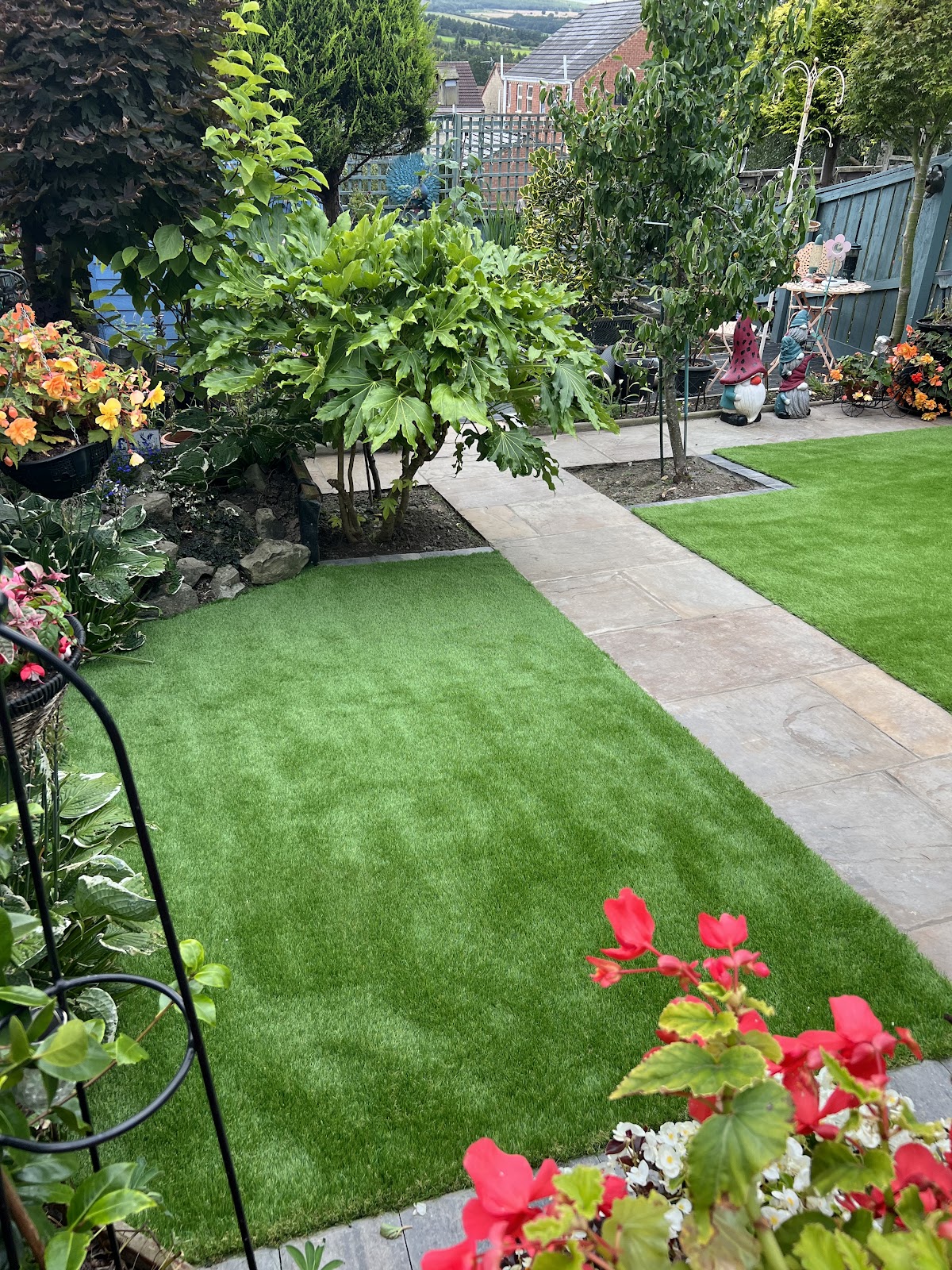 Mature planted garden with artificial lawn and a sandstone path running through it
